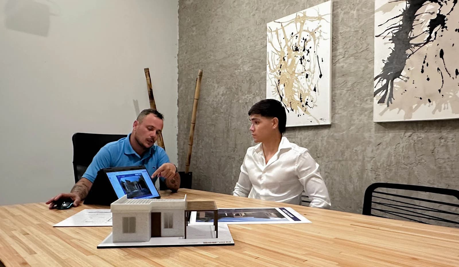Arquitecto de Nexa mostrando una maqueta a un cliente en el showroom