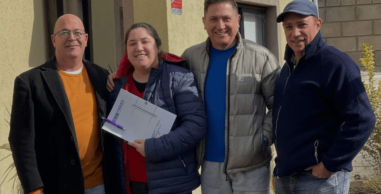 Familia en la puerta de su casa Nexa recién entregada